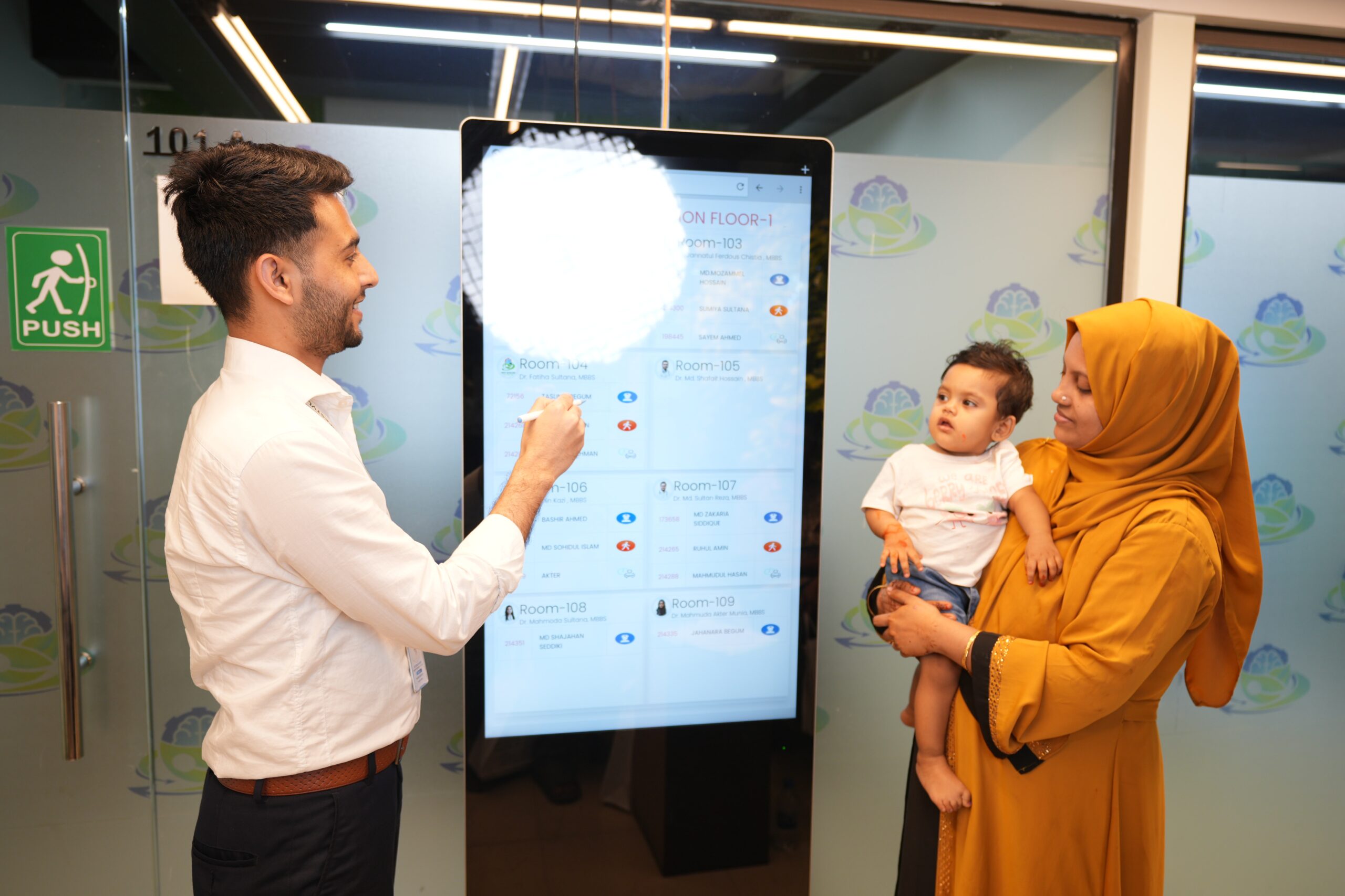 Healthcare staff assisting a mother and child with digital patient navigation and healthcare services at Health Revolution LTD.